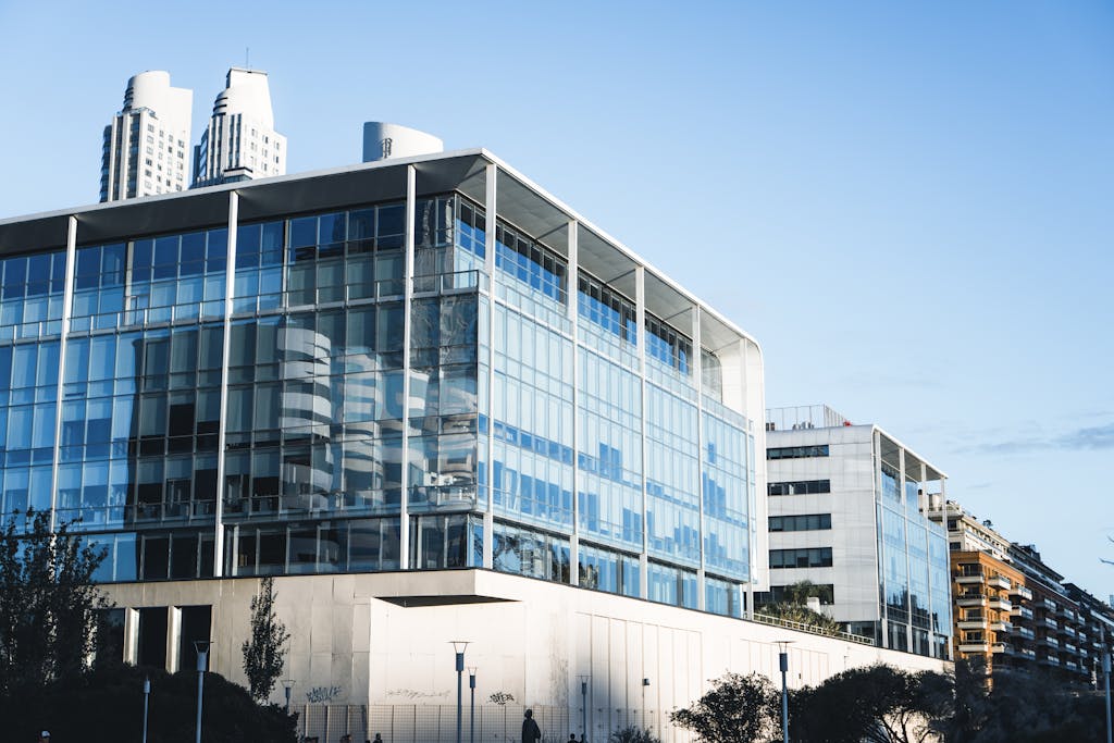 Low-angle view of a modern glass facade building in Buenos Aires' vibrant urban landscape.